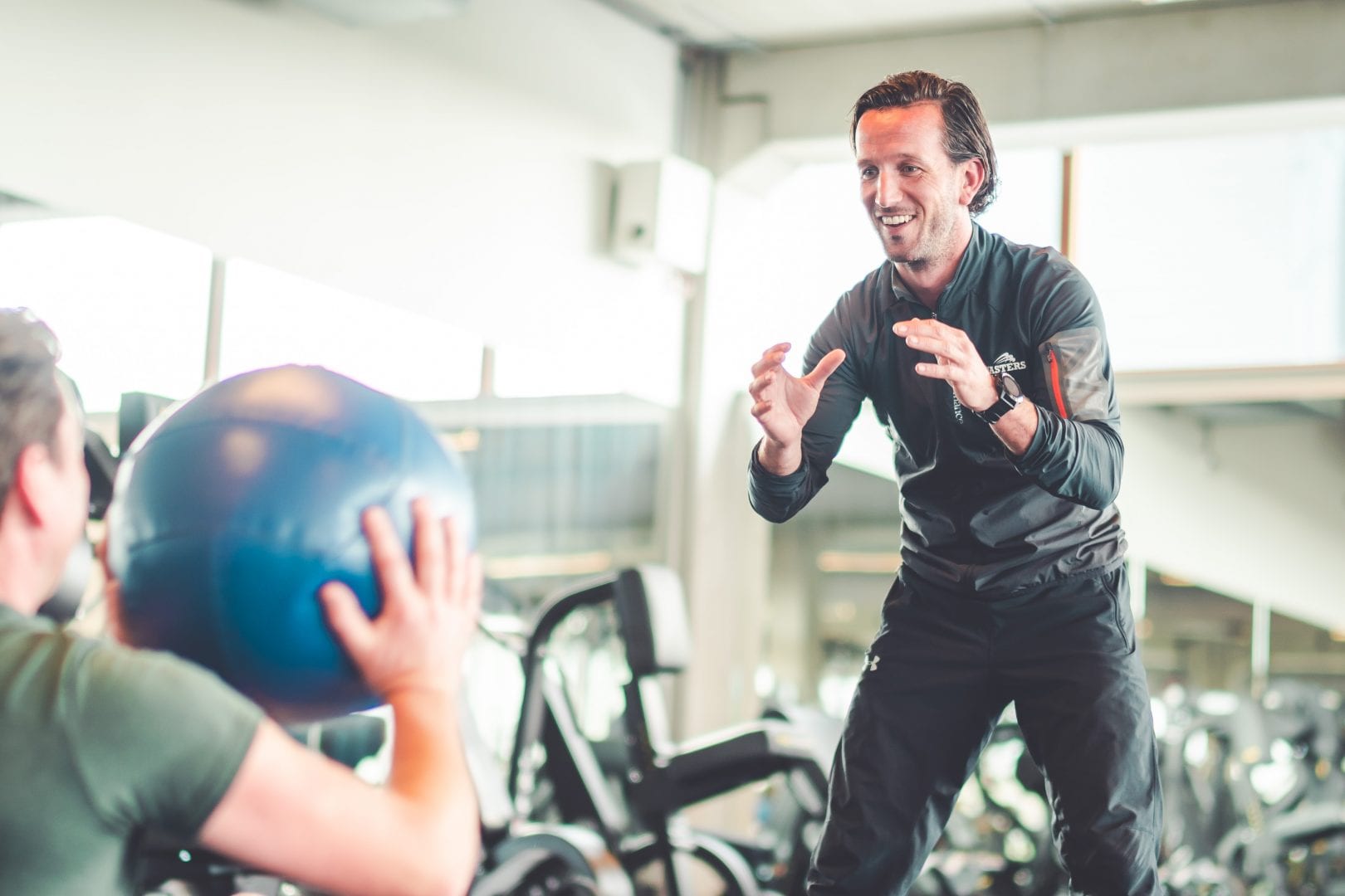 man gooit bal naar coach