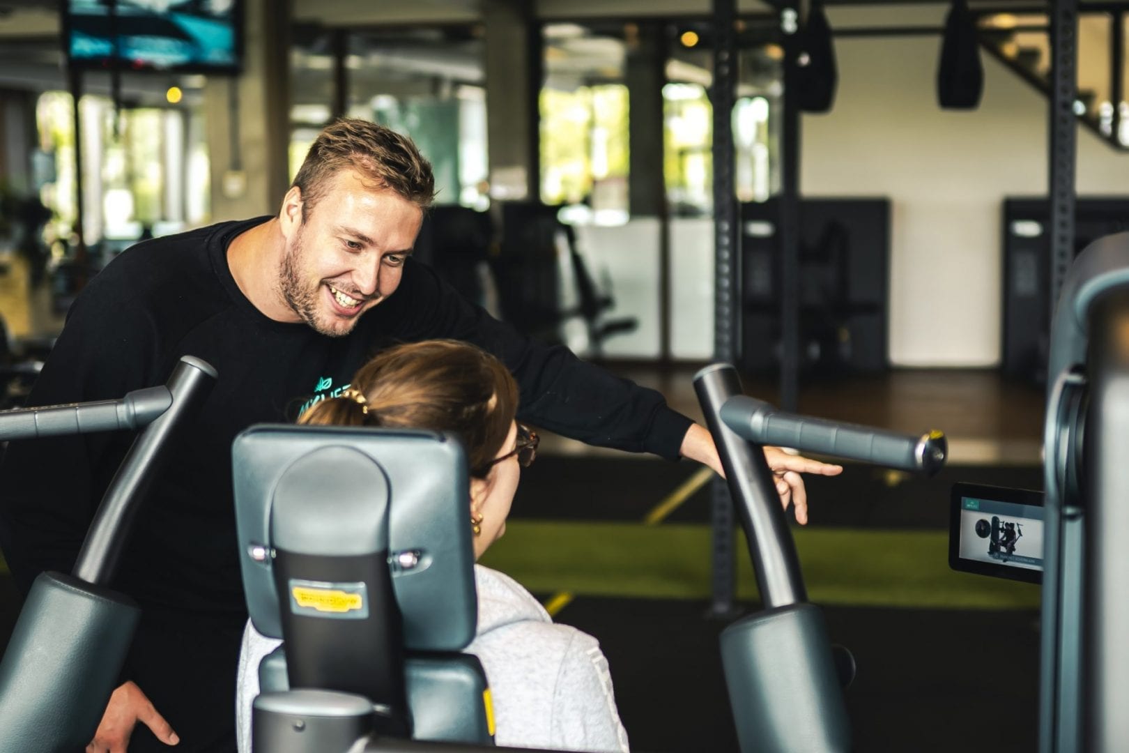 coach legt fitnessoefening uit aan vrouw
