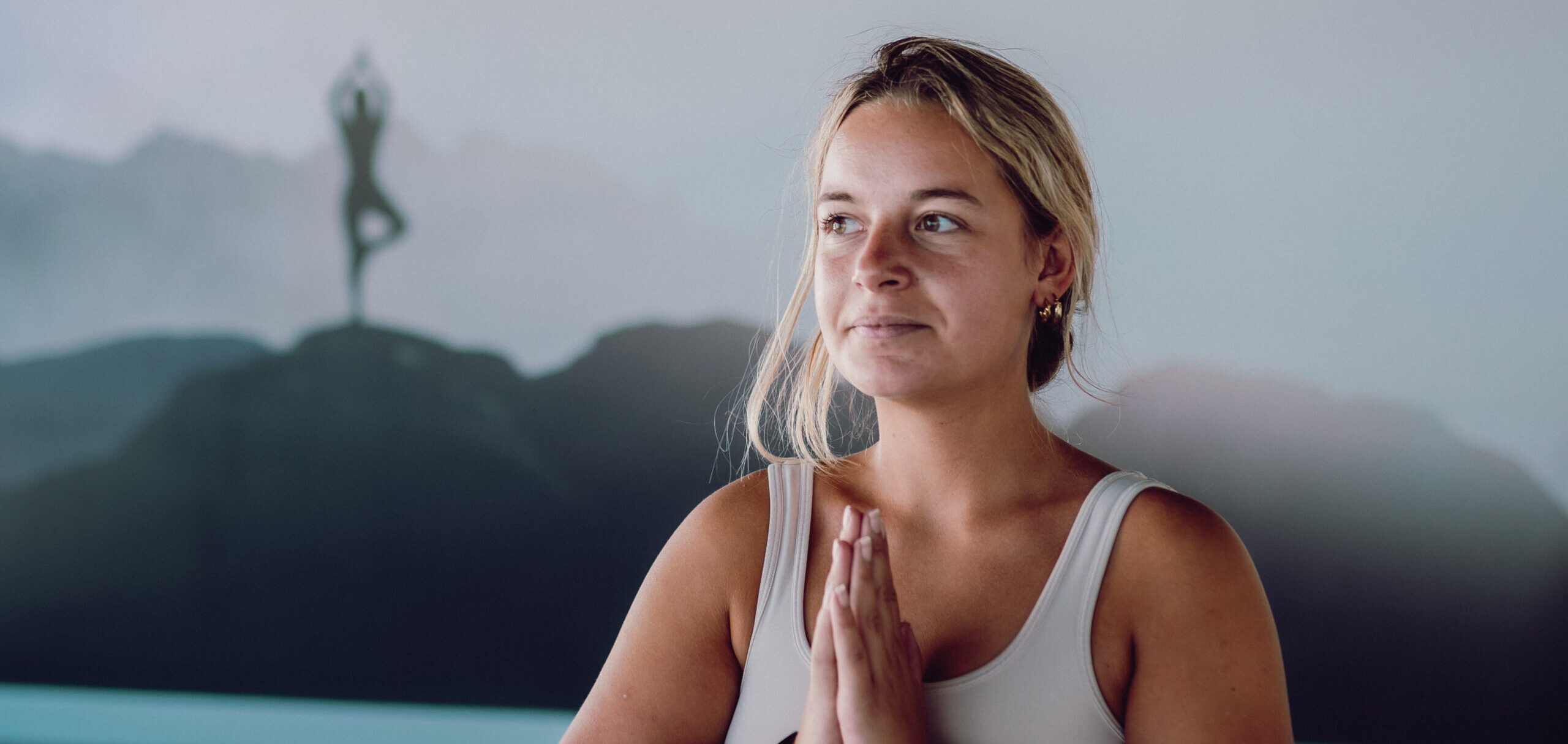 vrouw doet handen op elkaar in yoga pose